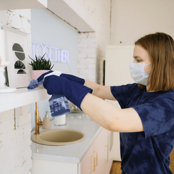 Maid cleaning commercial space shelves with microfiber cloth