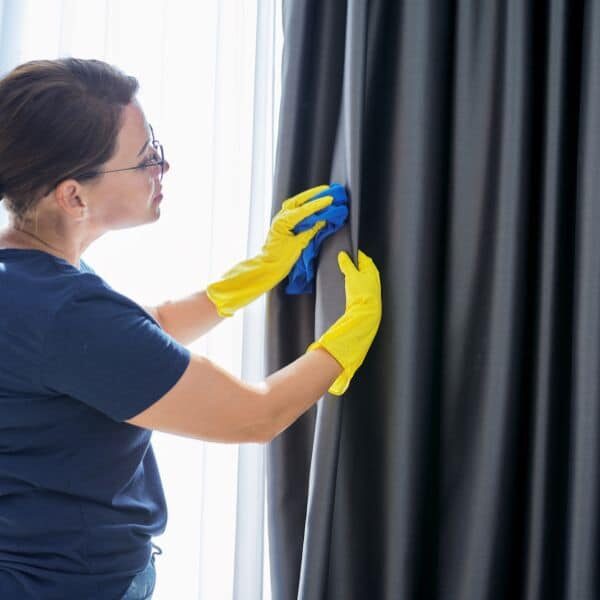 Woman deep cleaning home curtains